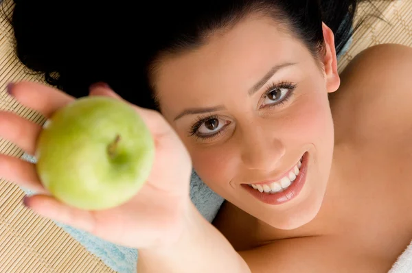 Sorrindo jovem mulher oferecendo uma maçã — Fotografia de Stock