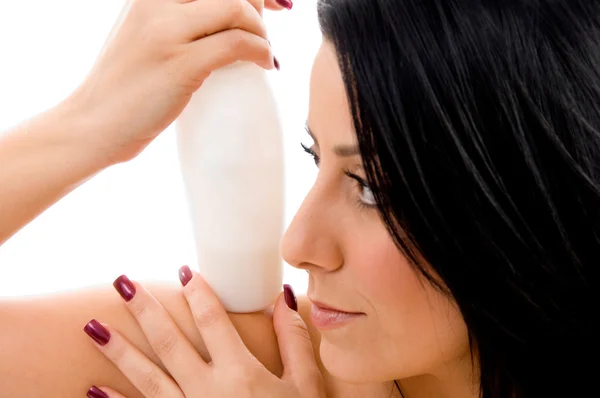 Young woman holding lotion bottle — Stock Photo, Image