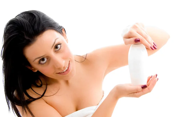 Молода жінка позує з пляшкою лосьйону — стокове фото