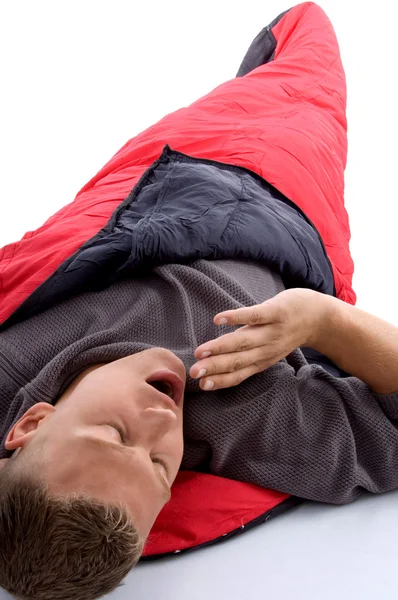 Человек в спальном мешке и зевает — стоковое фото