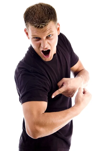 Кричащий человек, указывающий на свои мускулы — стоковое фото