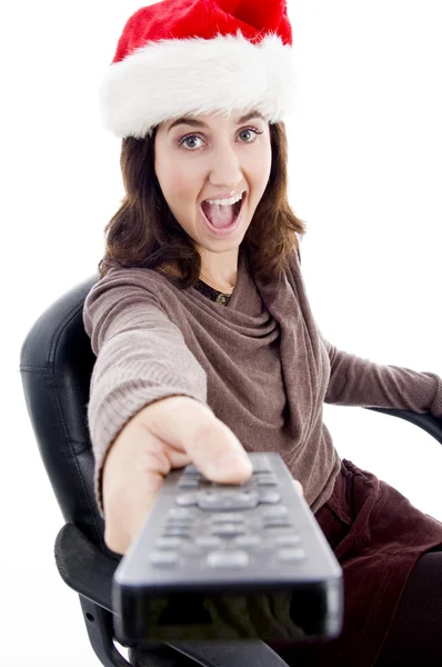 Frau mit Weihnachtsmütze opearting remote — Stockfoto