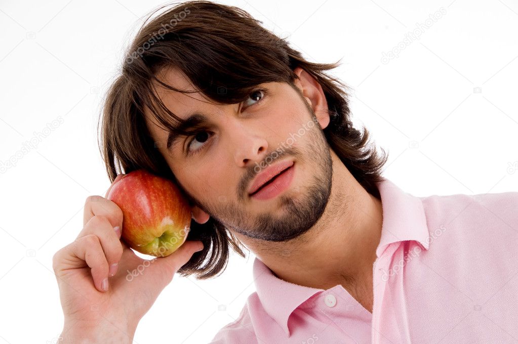 Male thinking and holding an apple
