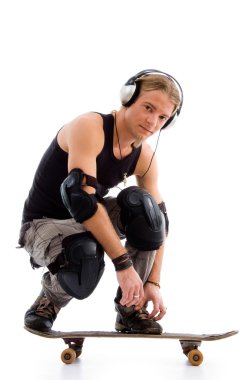 Male listening to music on skate board clipart