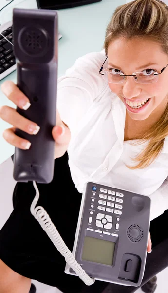 Female employee showing phone receiver — Stock Photo, Image