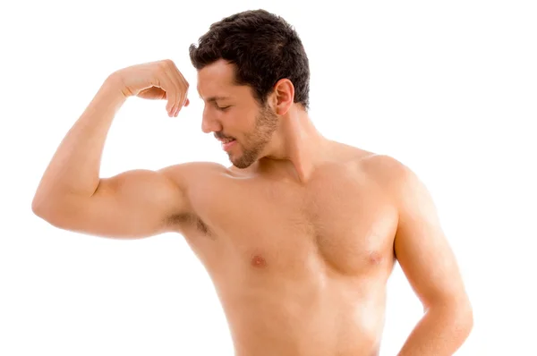 Hombre fuerte mirando sus músculos — Foto de Stock