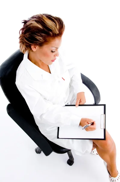Female doctor writing on notepad — Stock Photo, Image