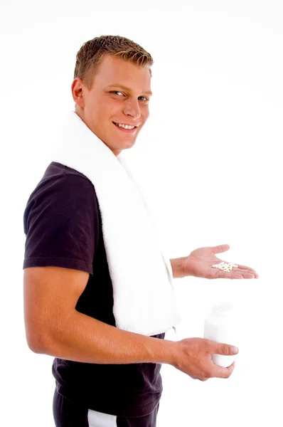 Sorrindo macho mostrando pílulas brancas — Fotografia de Stock