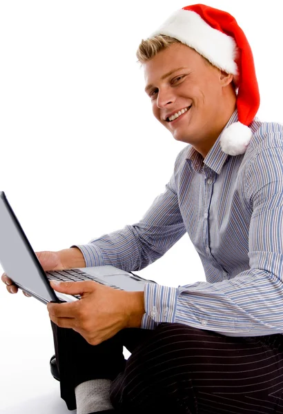 Ευτυχισμένος άνθρωπος με το καπέλο Χριστούγεννα και φορητό υπολογιστή — Φωτογραφία Αρχείου