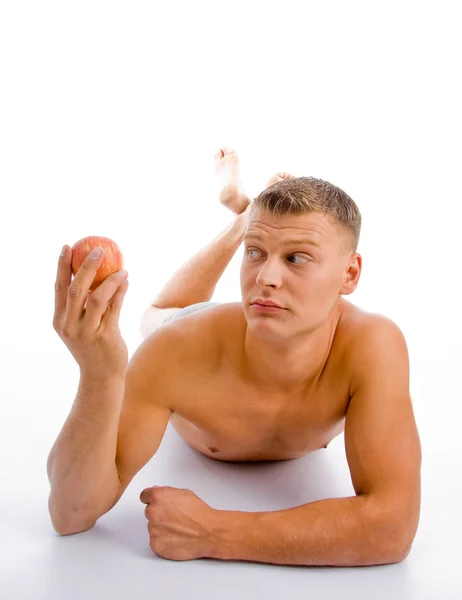 Muskulöser Mann mit einem Apfel in der Hand — Stockfoto