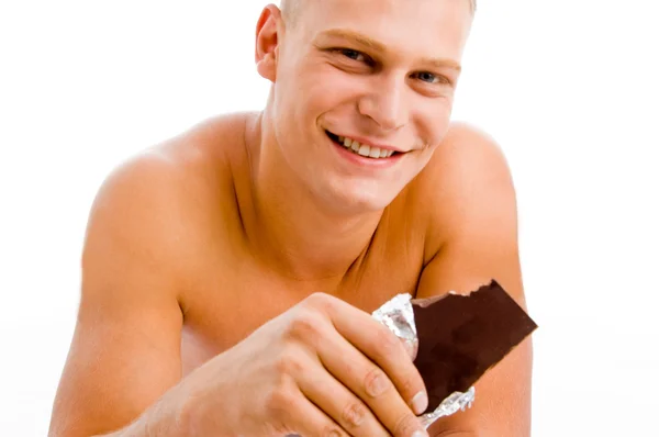 Lachende gespierde man met chocolade — Stockfoto