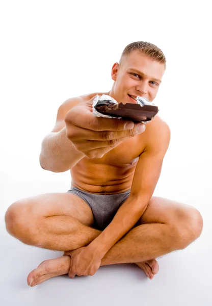 Muscular masculina oferecendo chocolate — Fotografia de Stock