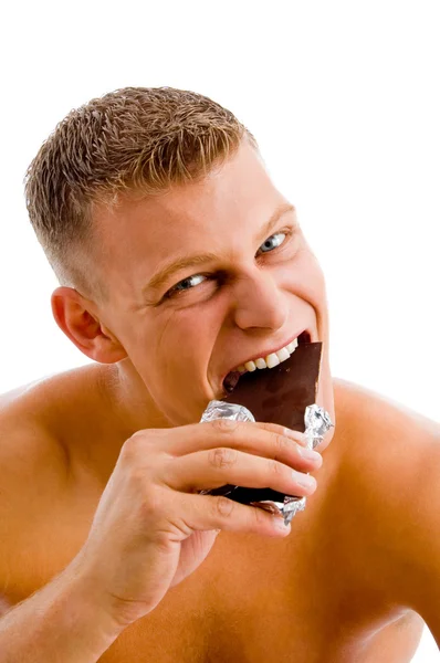 Muskulös man äta choklad — Stockfoto