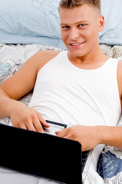 Man keeping laptop on his stomach — Stock Photo, Image