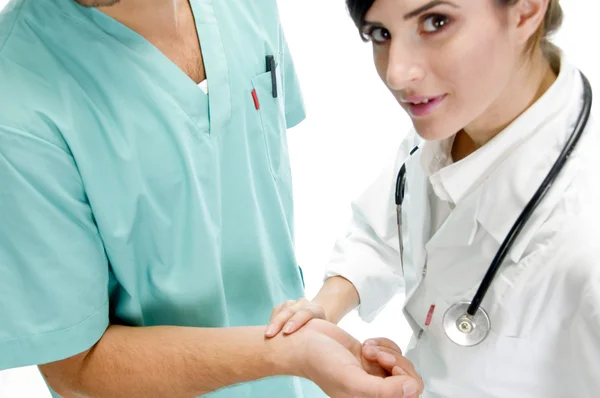 Молодая медсестра проверяет пульс — стоковое фото
