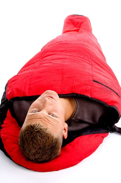 Jovem descansando em saco de dormir vermelho — Fotografia de Stock