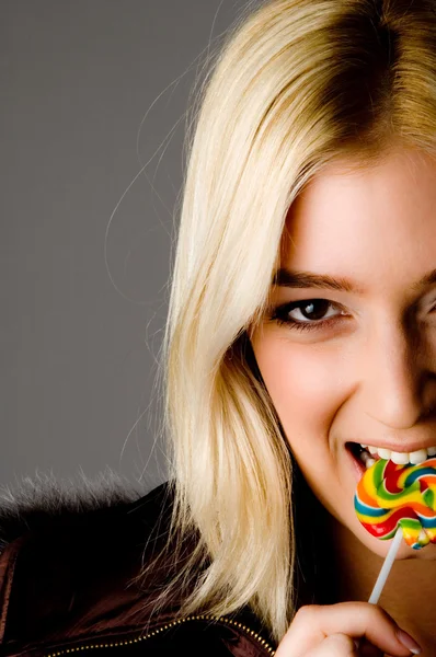 Smiling woman eating candy — Stock Photo, Image