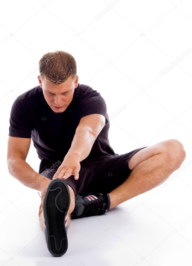 Muscular man stretching his legs