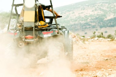 Couple driving a quad through mud clipart