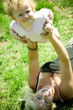 annesiyle oynayan gülümseyen şirin bebek