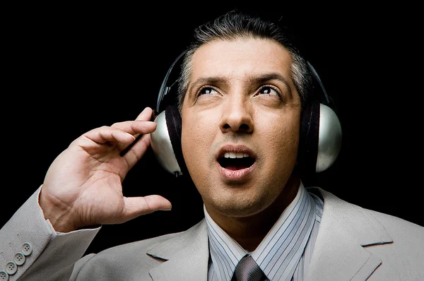 Дорослий бізнесмен слухає музику — стокове фото