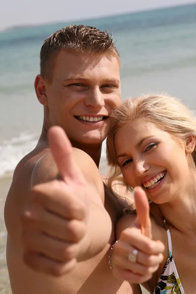 Young couple showing thumbs-up — Stock Photo, Image
