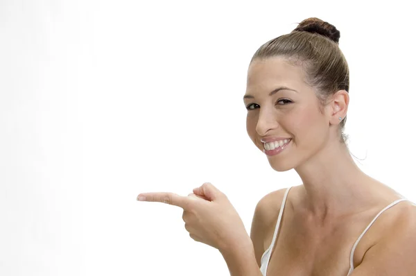 Unga leende kvinna som pekar — Stockfoto