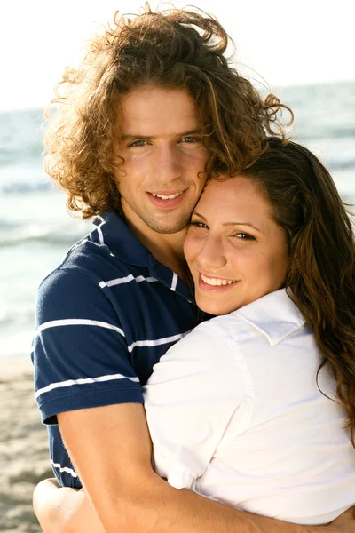 Bedårande par embracing på stranden — Stockfoto