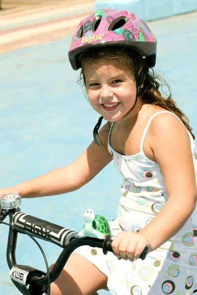 Menina andar de bicicleta com capacete de segurança — Fotografia de Stock