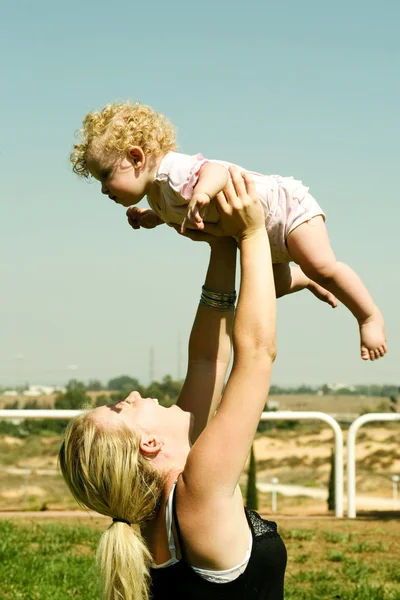 Mãe segurando seu filho alto — Fotografia de Stock