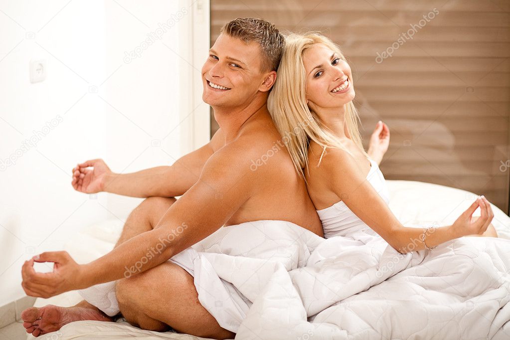Couple meditating in bed