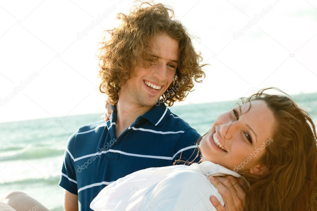 Young guy carrying woman in his arms