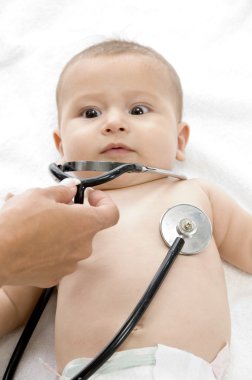 Doctor examining young baby clipart