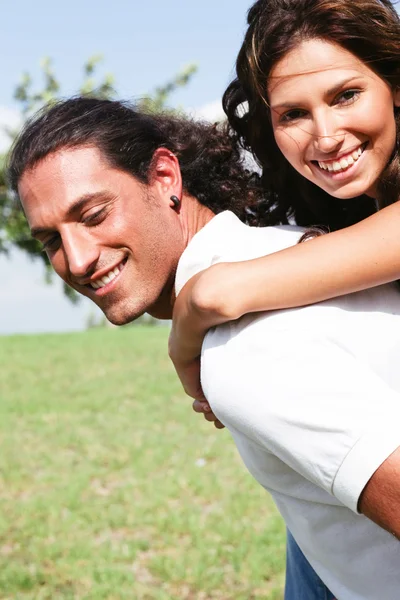 Χαμογελώντας ζευγάρι απολαμβάνει piggyback βόλτα — Φωτογραφία Αρχείου