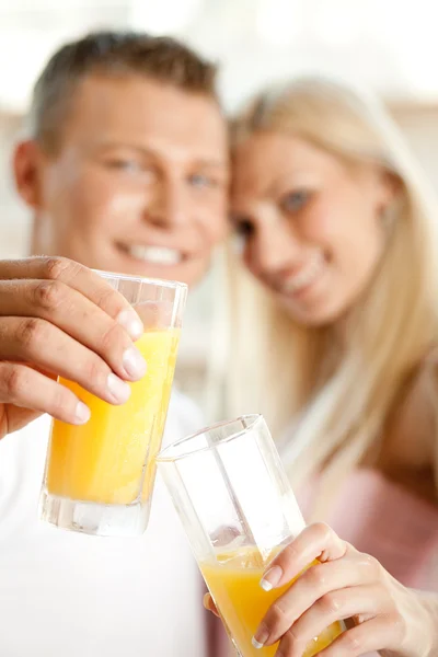 Couple holding juice glass — Stock Photo, Image
