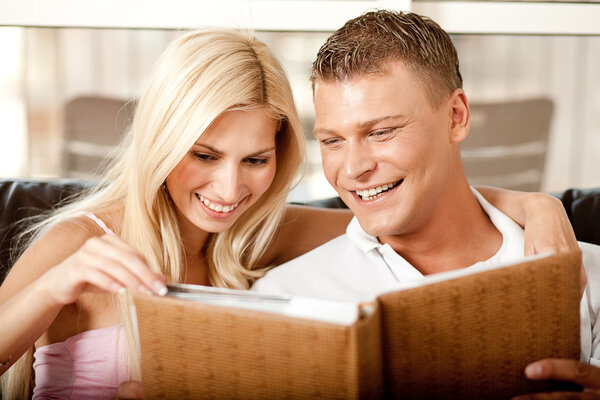 Smiling young couple sharing album