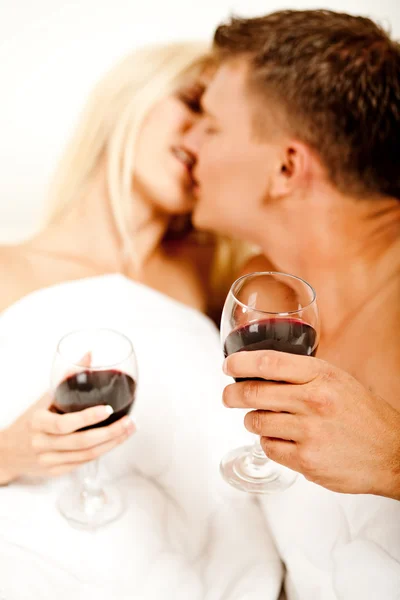 Пара держа бокал вина и целуясь — стоковое фото