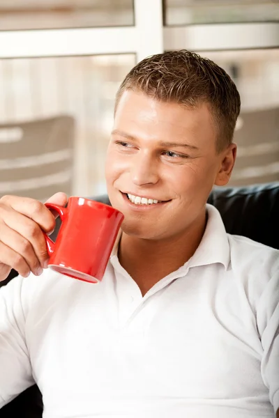 Leende kille dricker kaffe — Stockfoto