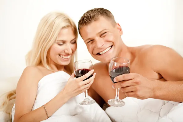Çift yatakta şarap paylaşımı — Stok fotoğraf