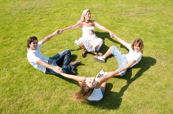 Familjen njuter tillsammans på gräs — Stockfoto