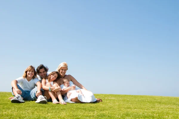 Šťastná rodina, ležící na trávě — Stock fotografie