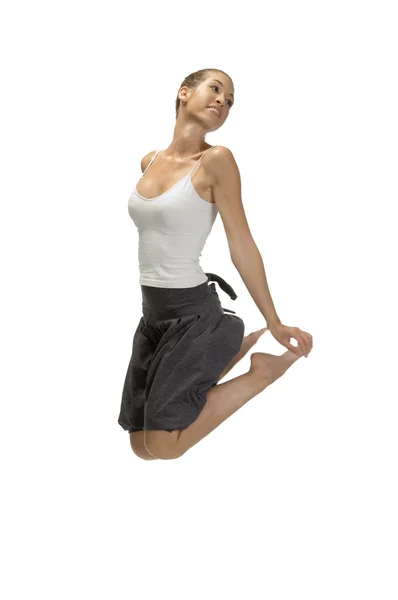 Jumping woman holding her legs — Stock Photo, Image