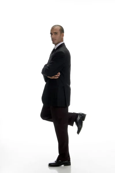 Молодой бизнесмен, стоящий на одной ноге — стоковое фото