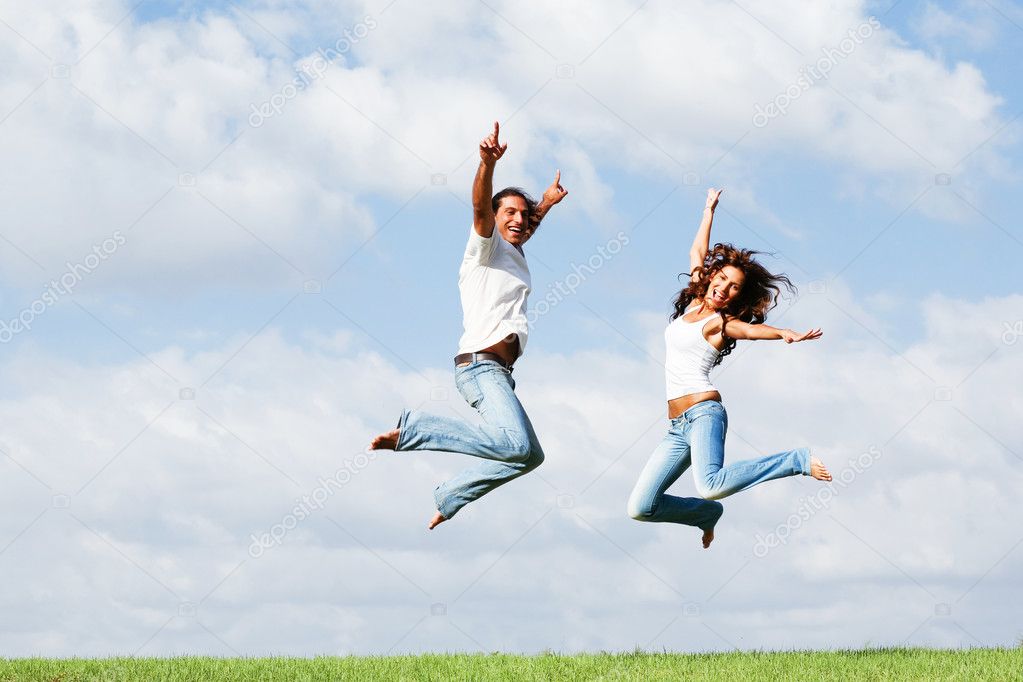 Playful couple jumping high in air