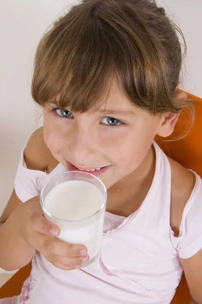 Usmívající se dívka se sklenicí mléka — Stock fotografie