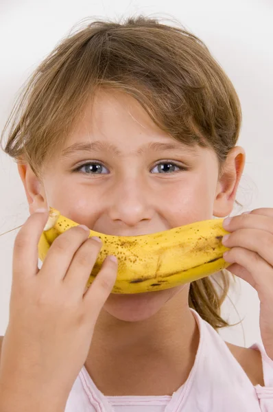 Lilla flicka äter banan — Stockfoto