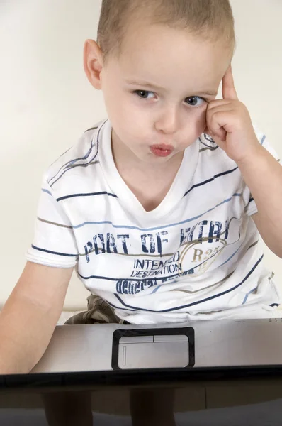 Kleines intellektuelles Kind mit Laptop — Stockfoto