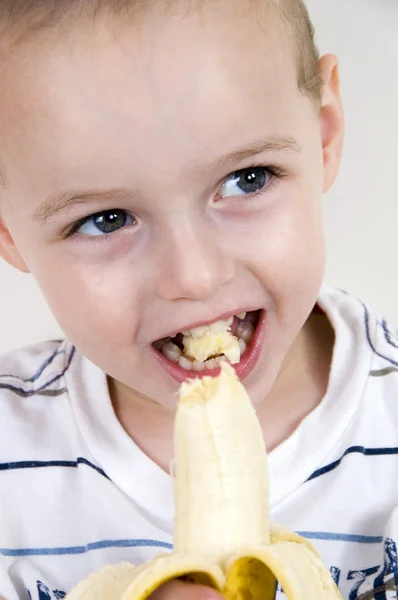 Крупный план здорового мальчика, поедающего банан — стоковое фото