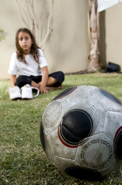 Ung pojke på gräs med fotboll — Stockfoto
