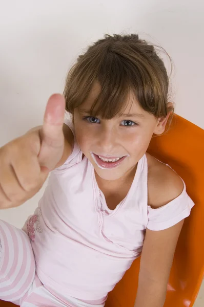 Милая маленькая девочка показывает большие пальцы вверх — стоковое фото